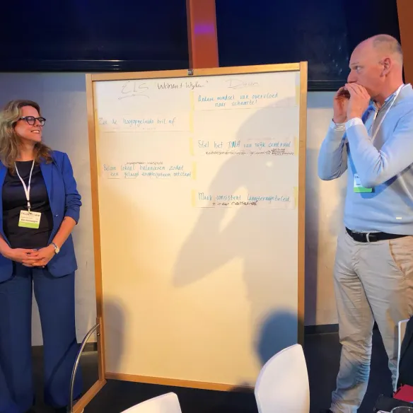 Twee mensen voor een whiteboard